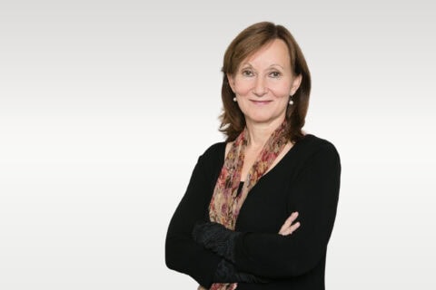 Porträt einer lächelnden Frau mit verschränkten Armen