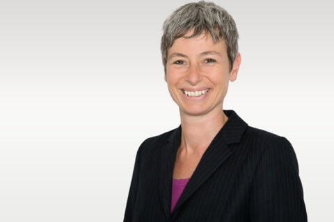 Lächelnde Frau mit kurzem grauem Haar im Blazer